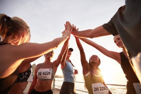 A team of marathon runners high five after a race