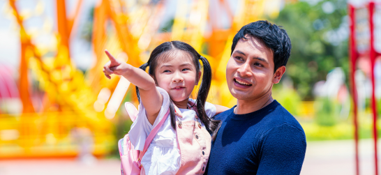 a man and his daughter outside of a roller coaster